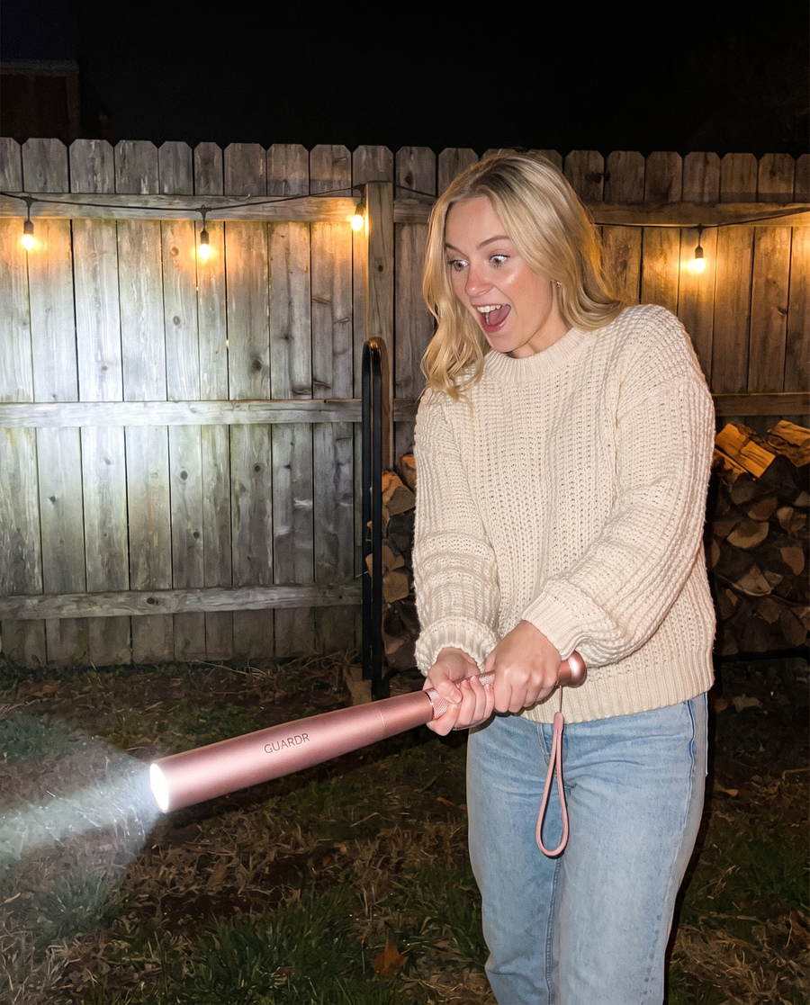 Woman using pink Guardr flashlight at night